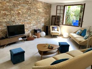 a living room with a couch and a tv at Villa avec piscine à Saze in Saze