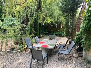 a table and chairs in a garden with a table and chairs at Villa avec piscine à Saze in Saze