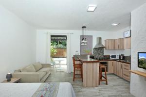 a kitchen and living room with a couch and a table at Charming studio in Moka 40 m² with mountain view terrace in Moka
