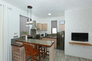 a kitchen with a table and chairs and a television at Charming studio in Moka 40 m² with mountain view terrace in Moka