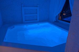 a bath tub with blue lighting in a room at Playa del Mar - Adults Only in Monopoli