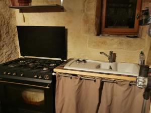 a kitchen with a stove and a sink at Studio charmant à Bio avec jardin et piscine partagée, 32 m². in Bio