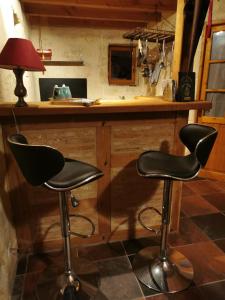 two black bar stools in front of a counter at Studio charmant à Bio avec jardin et piscine partagée, 32 m². in Bio