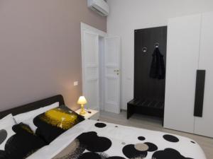 a bedroom with a bed with a black and white comforter at Contemporary Apartment in Trapani, 50 m² with Balcony in Trapani