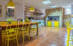 a kitchen with a wooden table and yellow chairs at Spacious House in Can Trabal in Can Trabal