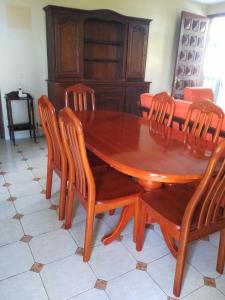 a wooden dining room table with chairs and a table at Appartement panoramique Bouillante in Bouillante