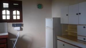 a kitchen with white cabinets and a refrigerator at Appartement panoramique Bouillante in Bouillante