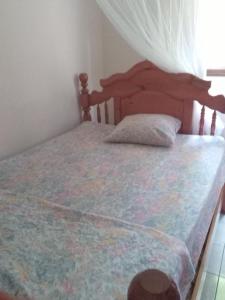 a bedroom with a bed with a wooden headboard at Appartement panoramique Bouillante in Bouillante