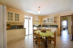 a kitchen with a table and chairs in a room at Villa charmante à Saint-Didier avec piscine privée in Saint-Didier