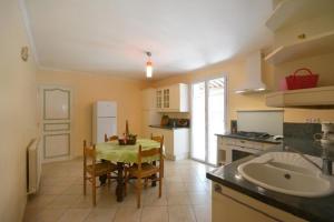 a kitchen with a table and a kitchen with a sink at Villa charmante à Saint-Didier avec piscine privée in Saint-Didier