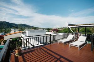 a balcony with two white chairs and a view at The One Apartment in Rawai Beach
