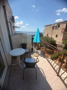 a patio with a table and chairs and an umbrella at Adrasteja 3 - apartment Dramalj in Dramalj +2 photos