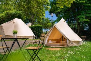 two tents in the grass with a table and chairs at Kampaoh Playa Troenzo in Celorio