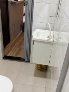 a white bathroom with a sink and a shower at Casa da Lu in Barreirinhas