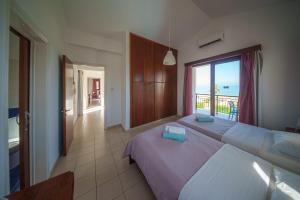 a bedroom with two beds and a view of the ocean at Ocean Breeze Club-Villa Mare in Kato Yialia +27 photos