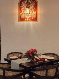 a dining room table with plates and flowers on it at Mahendra Prakash in Udaipur