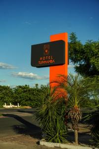 an orange and black hotel sign in a park at Hotel Tupinambá Timon in Timon