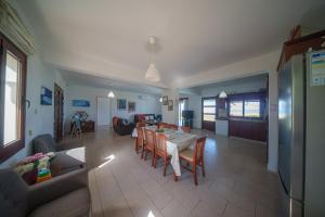 a dining room and living room with a table and chairs at Ocean Breeze Club-Villa Mare in Kato Yialia
