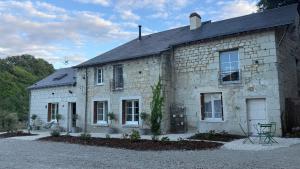 an old stone house with a gravel driveway at La vallée des grottes in Saint-Germain-sur-Vienne