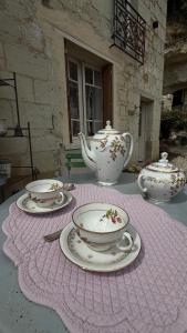 a table with four tea cups and saucers on it at La vallée des grottes in Saint-Germain-sur-Vienne