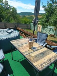 a wooden table and chairs on a patio at CHILLY WILLY Retro Caravan & Hot Tub in Jablonov nad Turnou