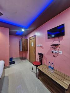 a room with a pink wall with a table and water bottles at DAS HOTEL in Darjeeling