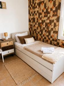 a bed in a room with a wall at Casa da Maré in Calheta