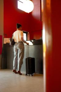 a woman standing at a counter with her luggage at Hotel Tupinambá Timon in Timon