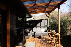 a patio with a couch and a table and a grill at Black Diamond - Pet Friendly, Magnesium Spa in Bright