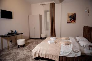 a bedroom with a bed and a desk and a table at Hotel Taurus in Solotvyno