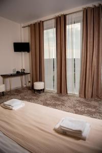 a hotel room with a bed and a window at Hotel Taurus in Solotvyno
