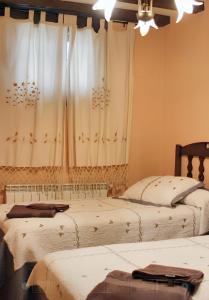 two beds in a room with a window at Family Apartment with Mountain View in Hueva in Hueva