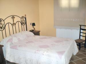 a bedroom with a large bed with a white blanket at Family Apartment with Mountain View in Hueva in Hueva