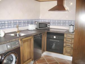 a kitchen with a sink and a microwave at Family Apartment with Mountain View in Hueva in Hueva