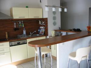 a kitchen with white cabinets and a wooden counter top at Appartement avec terrasse à Fréjus, 70 m², piscine partagée in Fréjus