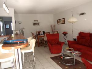a living room with a red couch and a table at Appartement avec terrasse à Fréjus, 70 m², piscine partagée in Fréjus