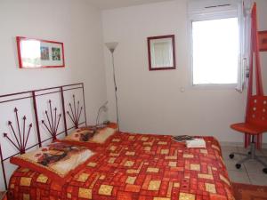 a bedroom with a bed and a chair and a window at Appartement avec terrasse à Fréjus, 70 m², piscine partagée in Fréjus