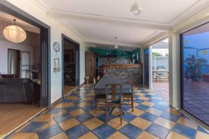 a living room with a table and chairs on a checkered floor at Villa élégante à Saint-Paul avec piscine privée ouverte toute l'année in Saint-Paul