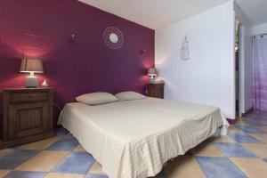 a bedroom with a bed and a purple wall at Villa élégante à Saint-Paul avec piscine privée ouverte toute l'année in Saint-Paul