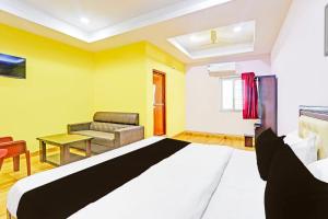 a bedroom with a large bed and a couch at Hotel O Nandhi Inn in Vemalwāda +23 photos