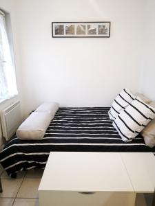 a couch with pillows and a table in a room at Studio cosy à Montargis - 13 m² - Parking inclus in Montargis
