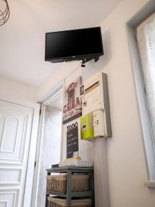 a flat screen tv hanging on a wall with boxes at Studio cosy à Montargis - 13 m² - Parking inclus in Montargis