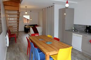 a kitchen and dining room with a wooden table and chairs at Appartement accueillant à Xonrupt-Longemer 70 m² avec jardin privatif in Xonrupt-Longemer