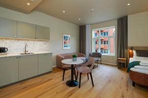 a kitchen and living room with a table and a bed at MAYA Apartments - Vika in Oslo +41 photos