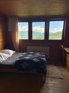 a bedroom with a bed and two windows with a view at 650m n.p.m. in Zawoja