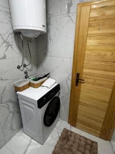 a washing machine in a bathroom next to a door at Hanovi Apartments in Borje