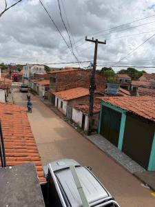 a city street with buildings and a car parked on the street at Casa da Lu in Barreirinhas