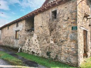 an old brick building with a sign on it at Kinvara Gite in Dournazac