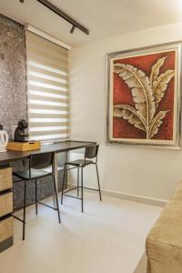 a dining room with a table and chairs and a painting at Dreamscape Central in Tirana +24 photos
