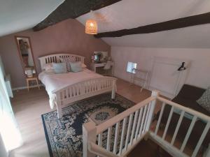 a bedroom with a white bed and a staircase at Kinvara Gite in Dournazac